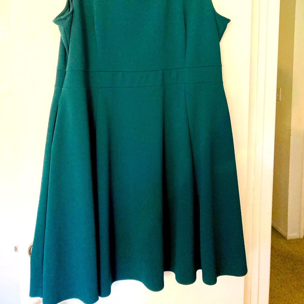 Sleeveless, knee length green dress.